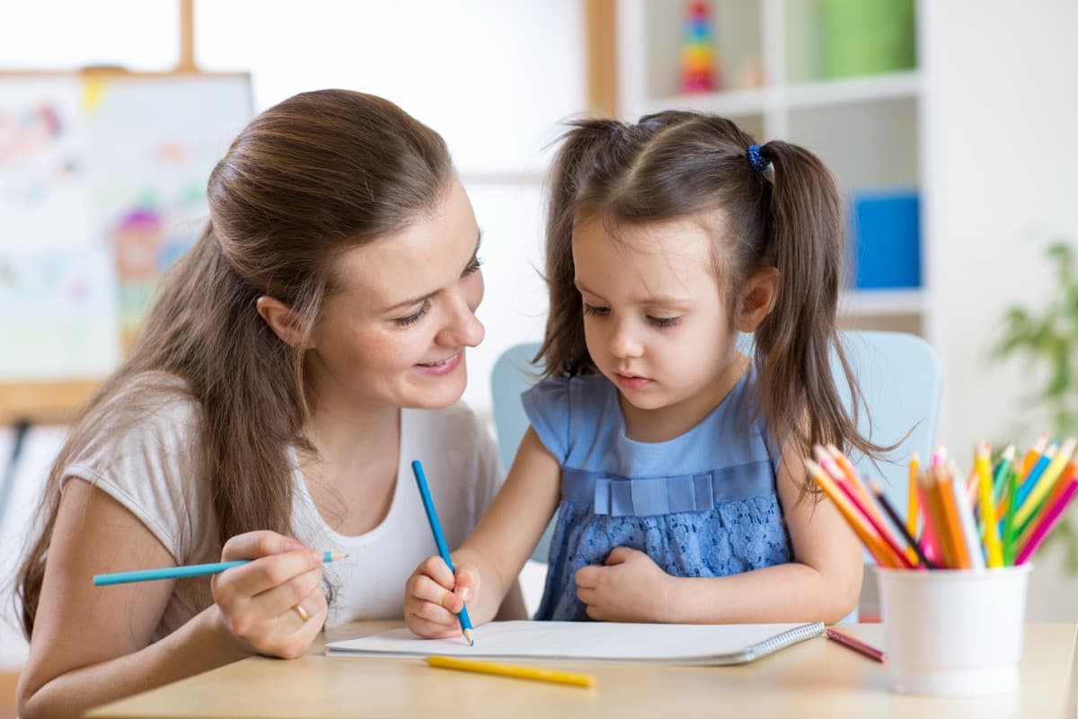 Caregiver and child talking in a bright living room at home